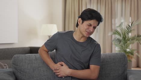 sick indian man suffering from stomach pain