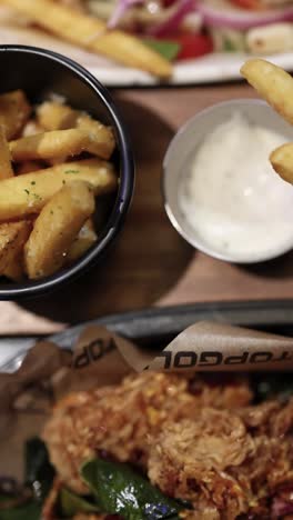 patatas fritas y alas de pollo con salsas de inmersión