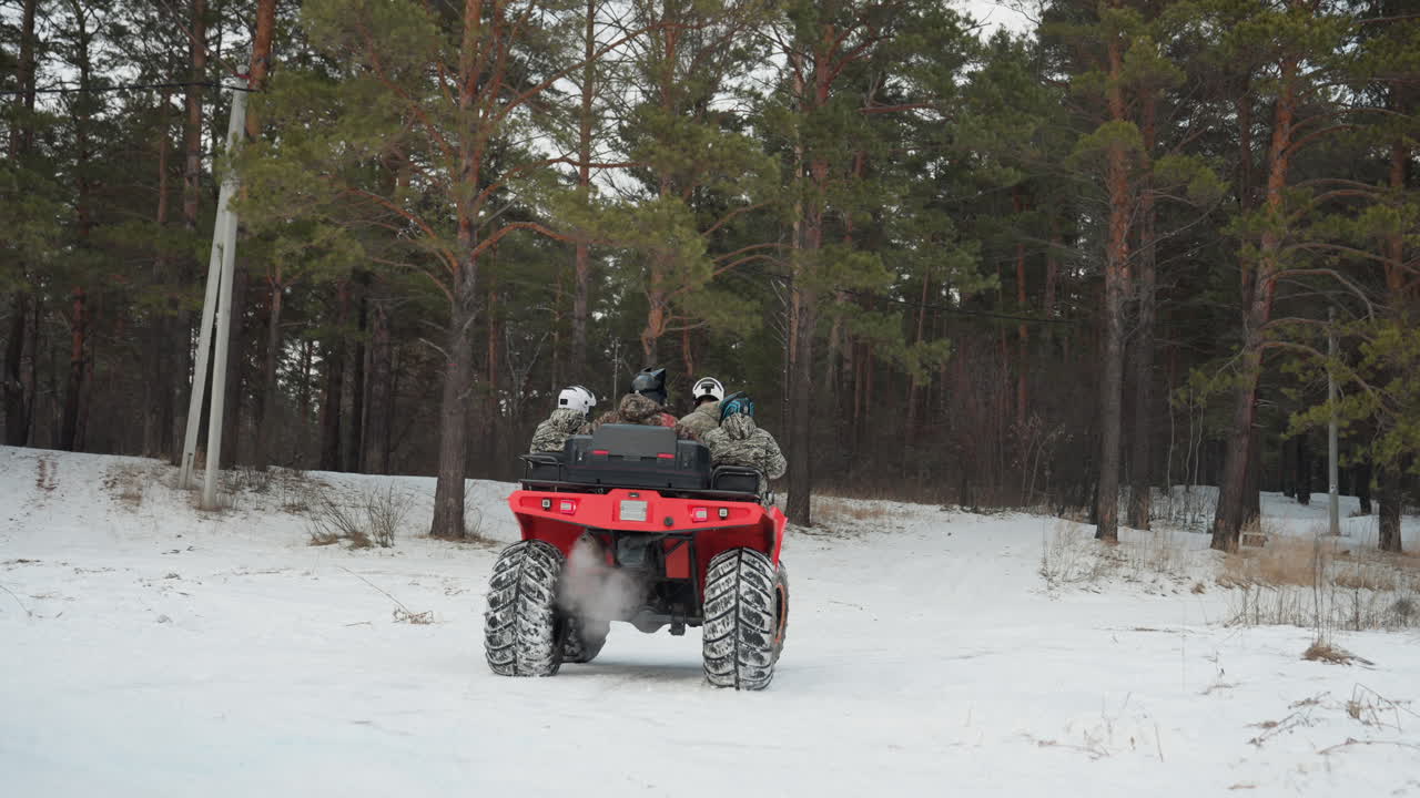 Pilota solitario esplora un paesaggio innevato. Esploratore solitario viaggia attraverso un bosco ghiacciato in ATV in inverno. Avventuriero solitario naviga attraverso boschi di pini ghiacciati in ATV durante la stagione nevosa.