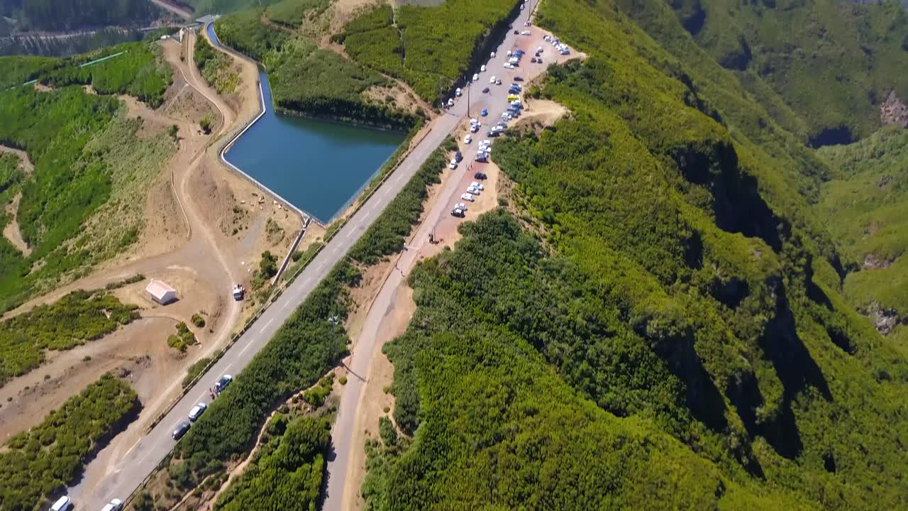 여름 동안 포르투갈, 마데이라, 라바칼에서 산의 전망을 감상할 수 있는 레바다 두 알레크림 인근 주차장에 주차된 차량의 공중 전망