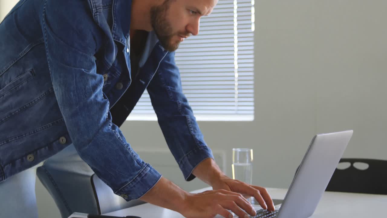 Male executive using laptop in conference room 4k