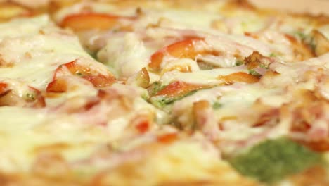 close-up of a delicious pizza with cheese, ham, and tomato toppings