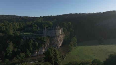 Reverse-flying-at-Medieval-Walzin-castle-Belgium-at-amazing-cliff,-aerial