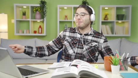 un estudiante alegre y feliz está estudiando mientras escucha música.