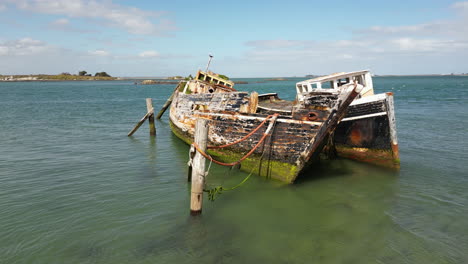 two abandoned shipwreck moored near coastline of new zealand, orbiting view