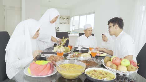 muslim girl chats with her family in dining room
