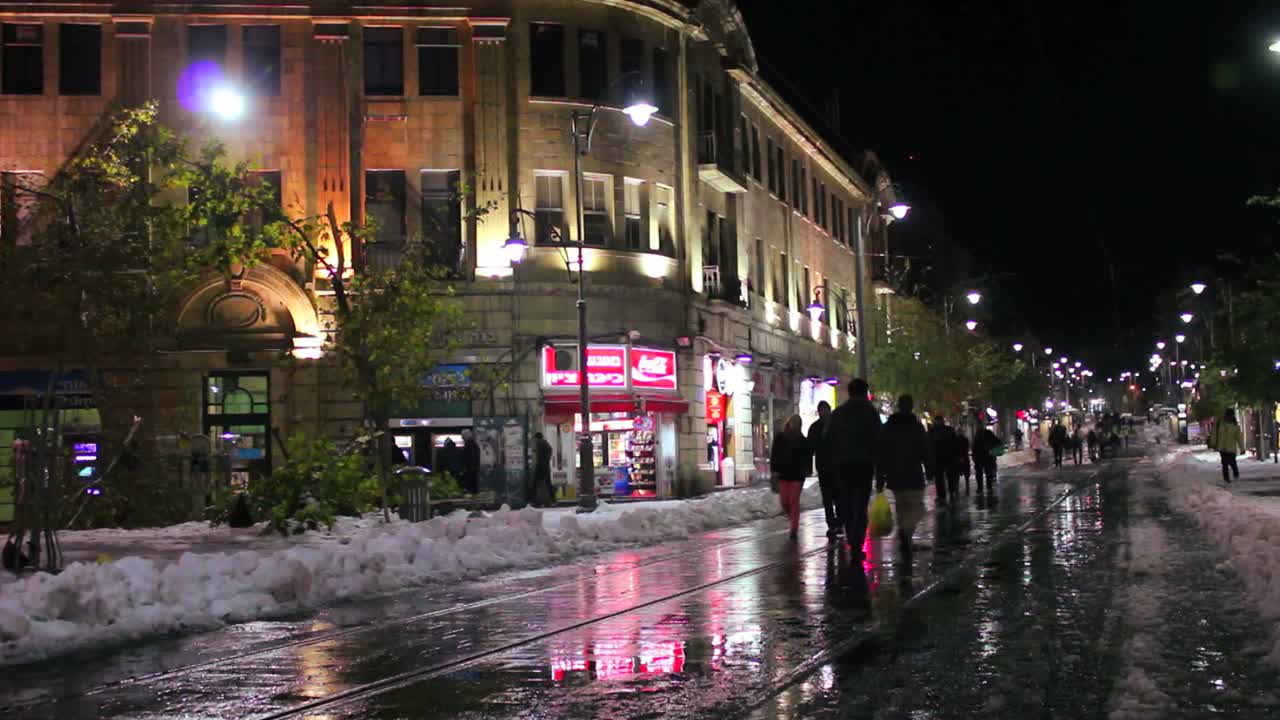 люди идут по необычно заснеженным улицам иерусалима ночью