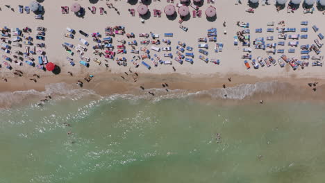 imágenes aéreas de arriba hacia abajo de turistas en la playa de bari, italia durante el día