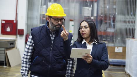 técnico enfocado y gerente de proyecto caminando con una tableta