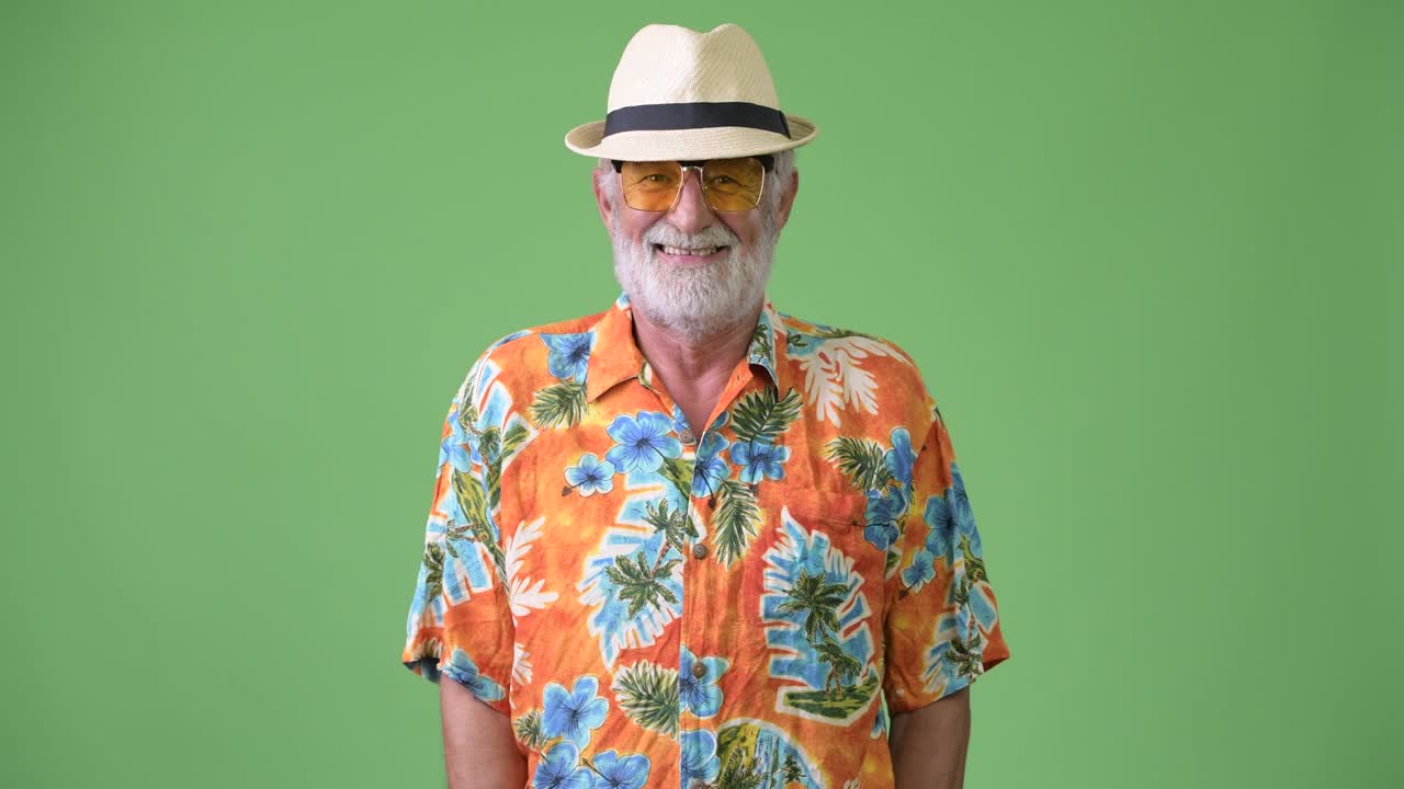 hombre turista barbudo y guapo listo para las vacaciones contra un fondo verde