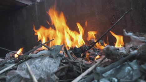 wide shot of burning trash with an open fire