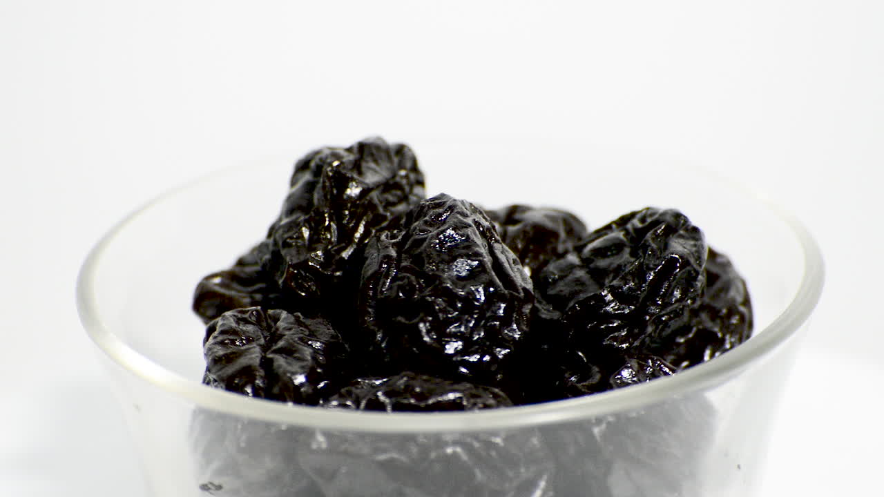 白い背景の上に回転するガラスの鍋に梅干し