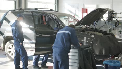 mecánico de automóviles inspeccionando el motor del automóvil en el taller
