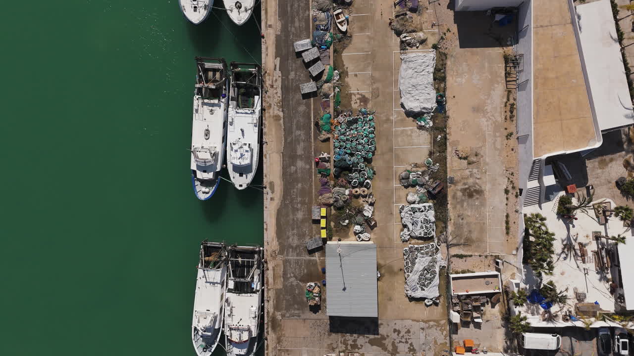Top-down view of boats docked along marina strip with parallel moorings and paths