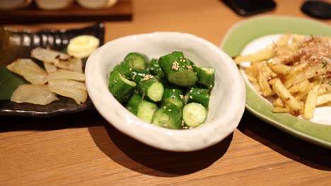 hands mixing vegetables with chopsticks in a bowl