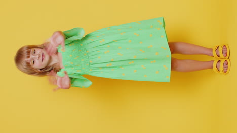 young cute school girl kid smiling friendly gesturing hello or goodbye, welcoming, waving hands