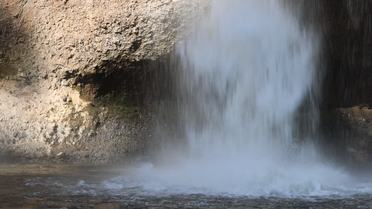 바위 아래로 흐르는 물이 무지개를 만니다.