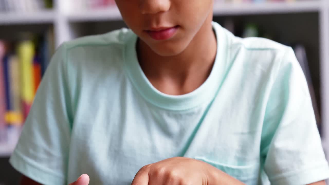 Schoolboy using digital tablet in classroom at school