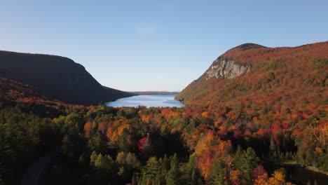 beautiful aerial drone footage of the fall leaves on and around mount hor, mount pisgah, and lake willoughby during peak autumn foliage at willoughby state forest in westmore, vermont