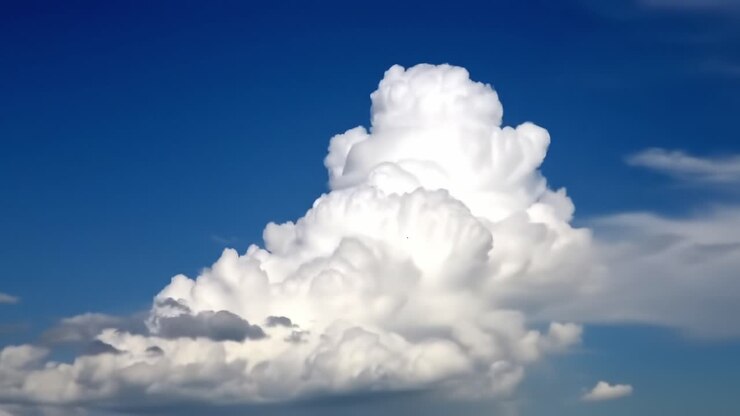 Ein atemberaubendes Schauspiel dynamischer Wolkenformationen unter einem klaren blauen Himmel, das die Eleganz und Majestät der sich ständig wandelnden Himmelskunst der Natur einfängt