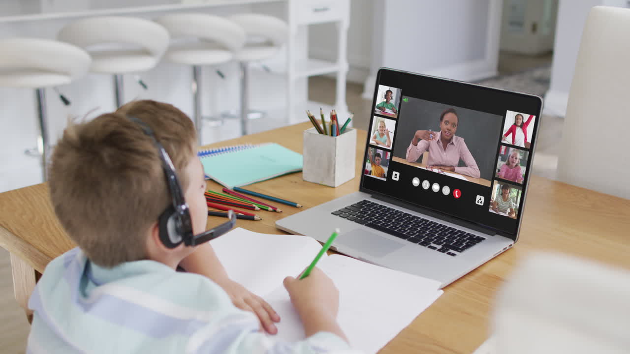escolar que usa una computadora portátil para una lección en línea en casa, con un maestro y una clase diversos en la pantalla