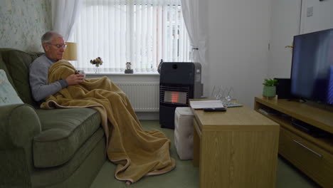 a senior person trying to keep warm during the energy crisis