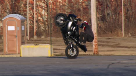 Ein-Fahrer-Führt-Stunts-Auf-Einem-Motorrad-Auf-Einem-Parkplatz-Aus-2