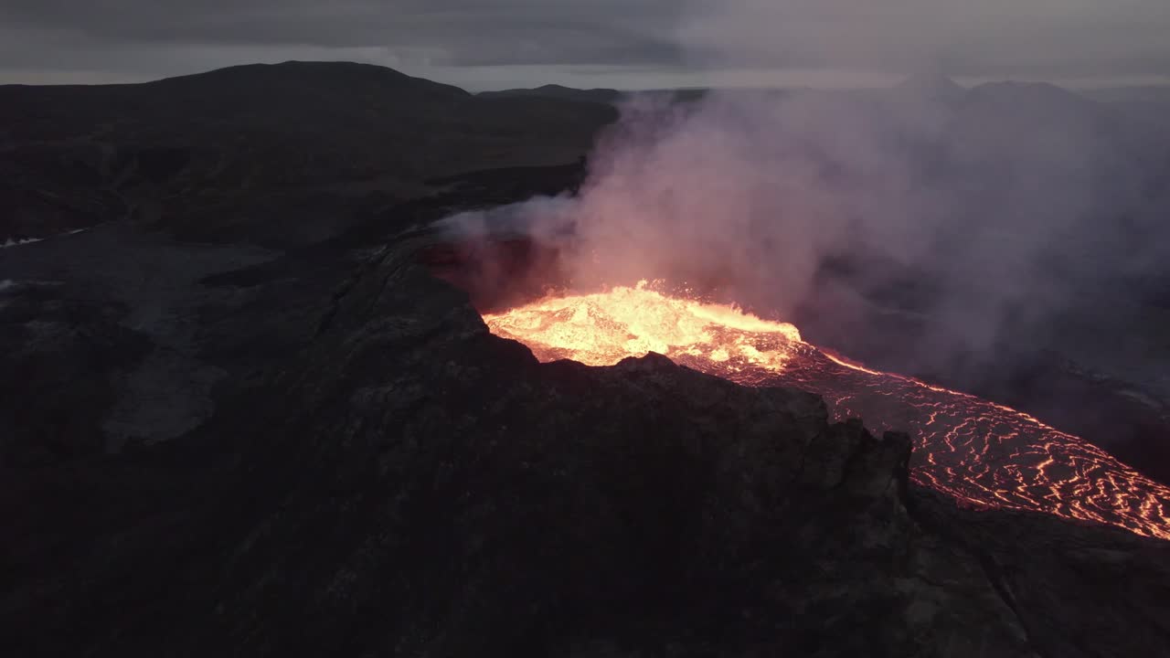 Aerial view towards a spawning and smoking magma basin - approaching, drone shot