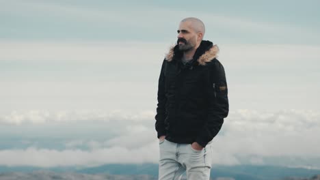 Motivated-young-Caucasian-man-with-mustache-turns-to-face-stunning-mountain-landscape,-taking-in-the-view