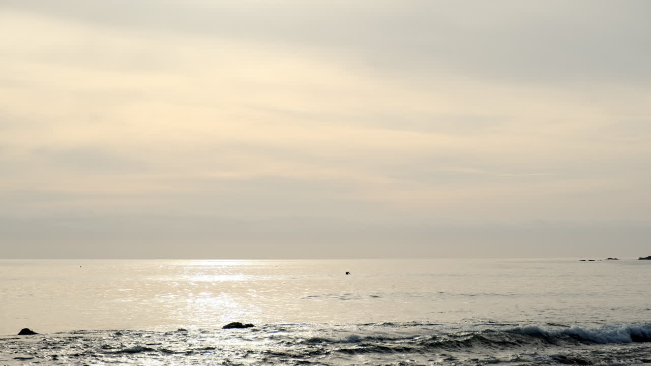 캘리포니아 말리부의 큰 바위 해변에서 솔로 서퍼 학습과 함께 황금 시간에 고요한 바닷물