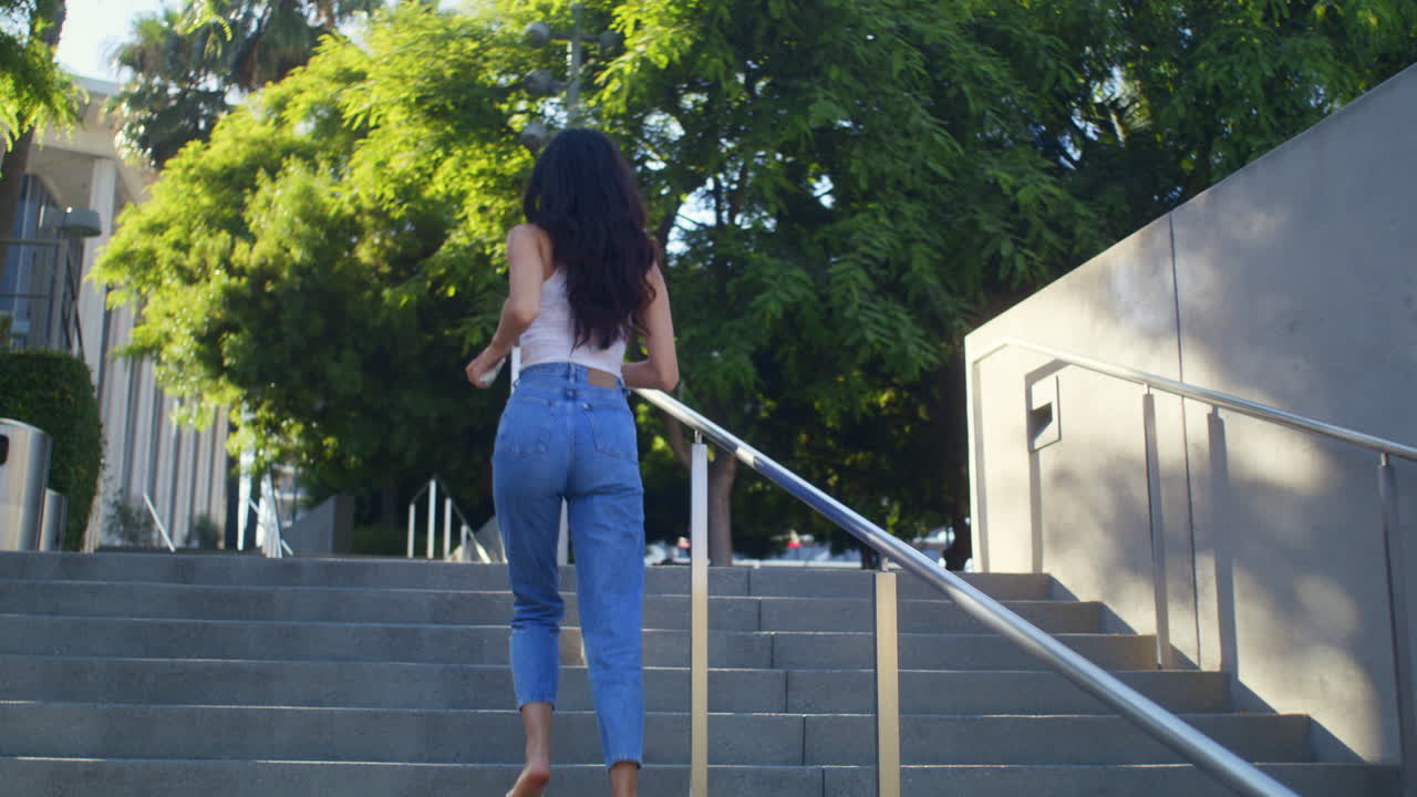 Mulher ativa subindo escadas correndo para tirar foto da cidade. Garota asiática subindo.