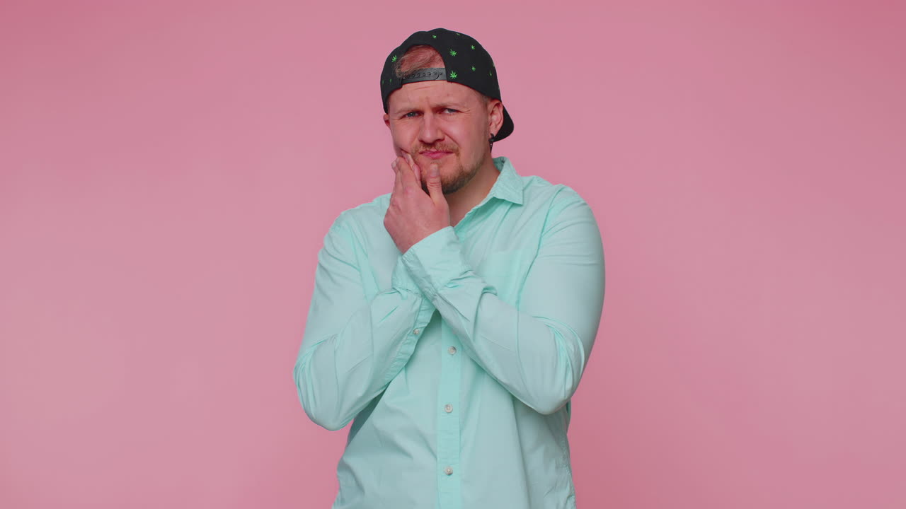 Man touching cheek suffering from toothache cavities or gingivitis waiting for dentist appointment