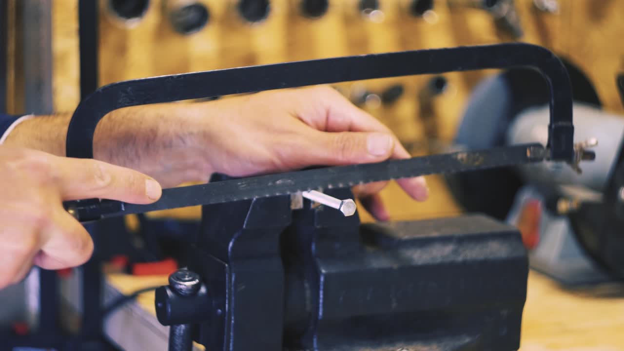 Male hands sawing a bolt