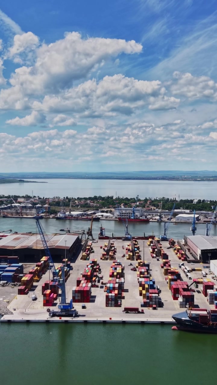 Cargo port with shipping containers and cranes on sunny day