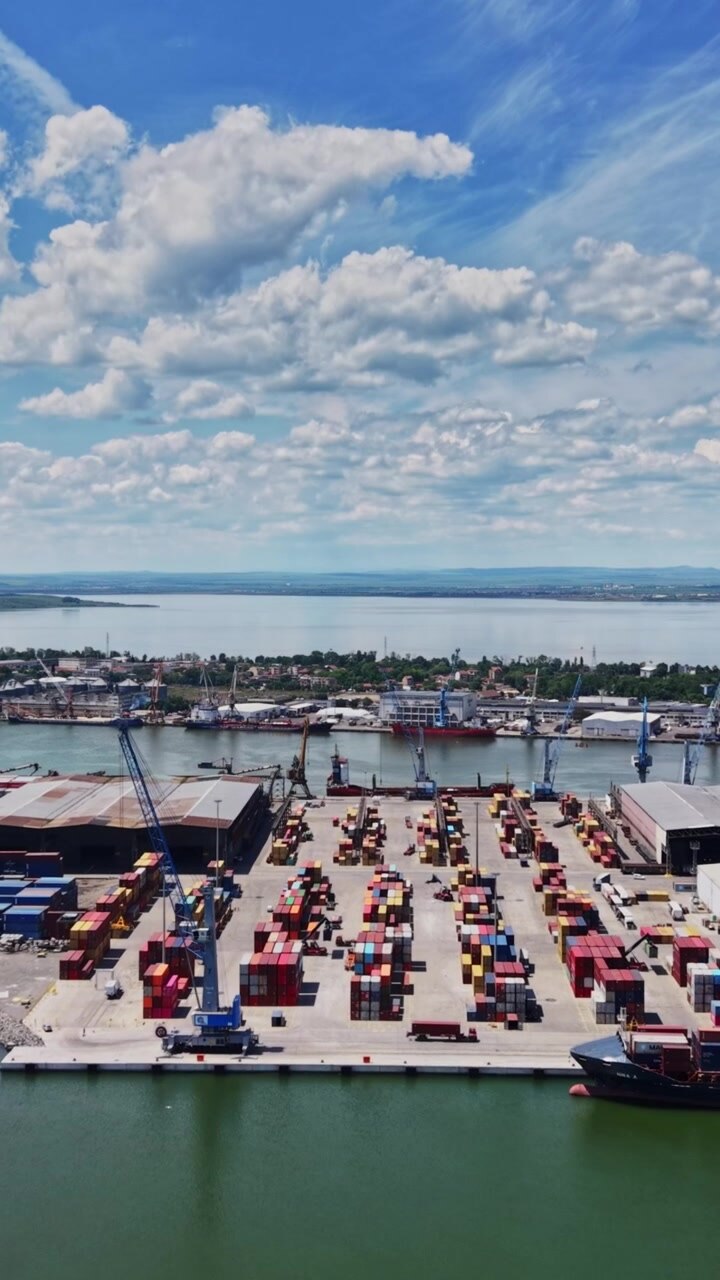 Cargo port with shipping containers and cranes on sunny day