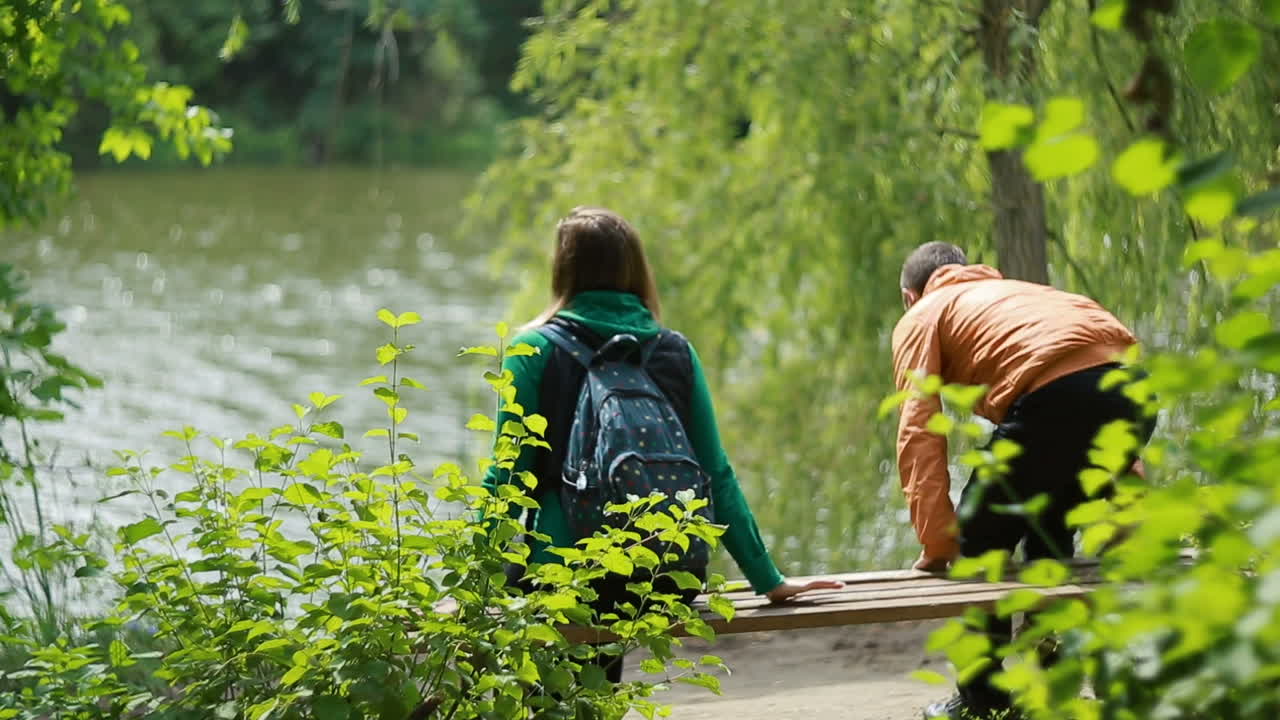 Couple Sitting On A Bench. Beautiful young couple sitting on a bench in the park
