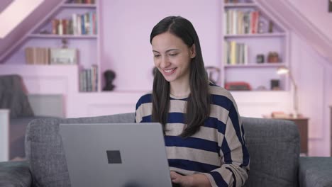 chica india feliz usando computadora portátil