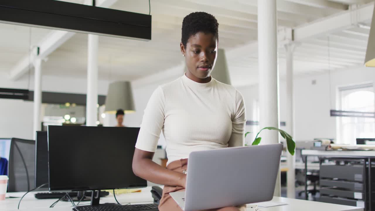Focused african american businesswoman working on laptop in office