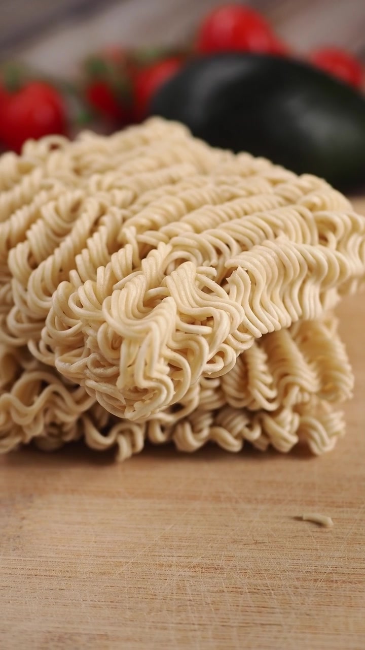 Blocco di noodle istantanei secchi su tagliere di legno