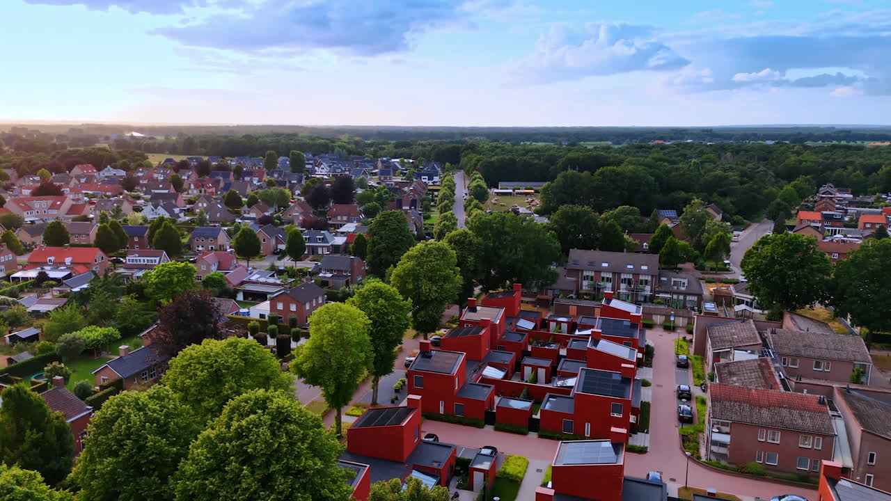 Lively area with modern design. Aerial view of a colorful neighborhood featuring modern homes surrounded by lush greenery during twilight