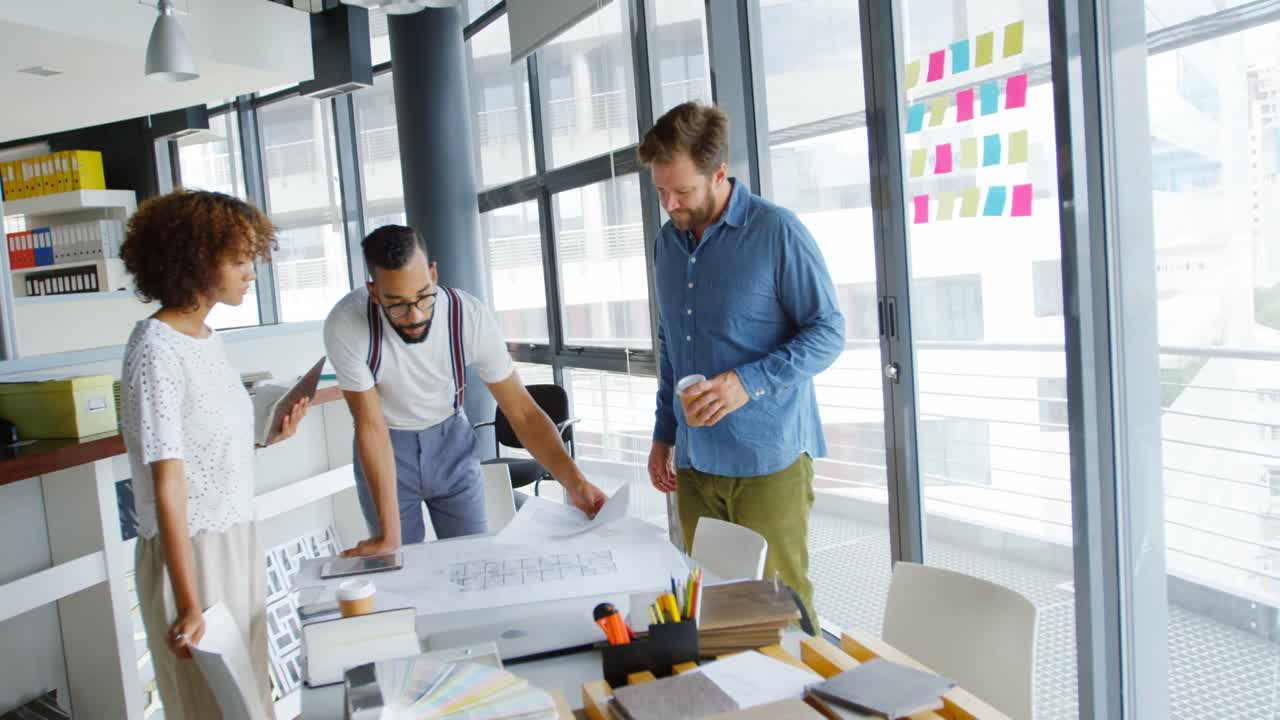 Business colleagues discussing over blueprint 4k