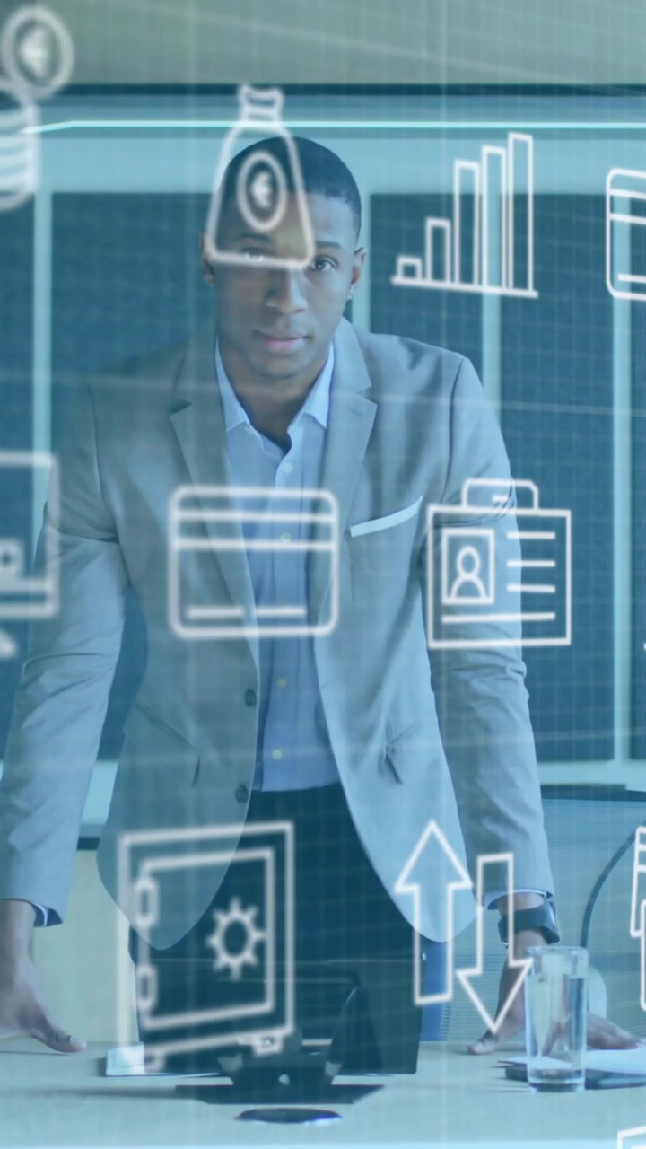 Businessman in office with data analytics and business icons animation over him