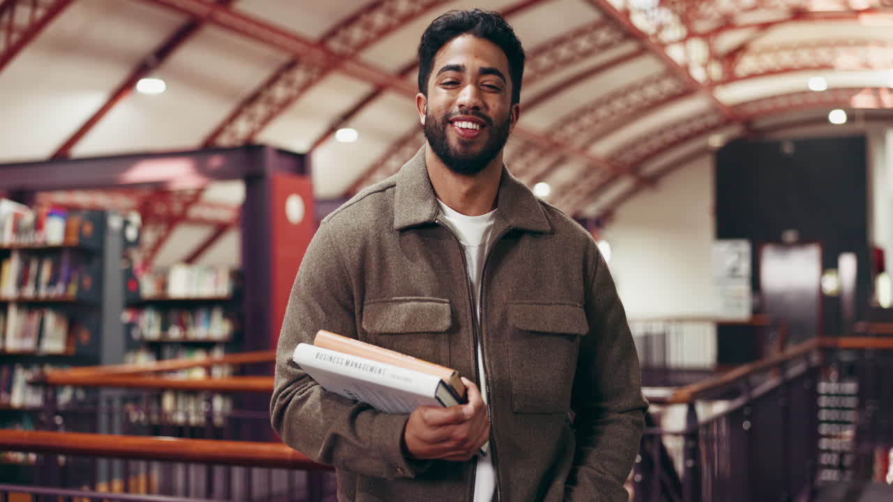Student in a library holding business management books