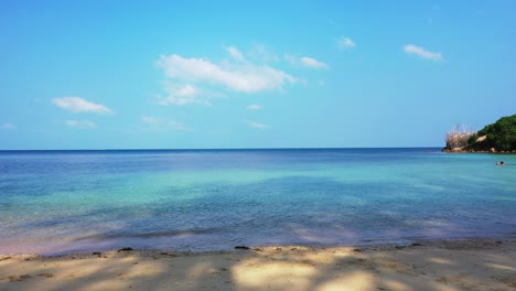 idyllic quiet sandy beach washed by calm clear water of shallow turquoise lagoon at sunrise bright sky in jamaica