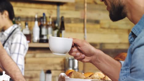 Male-customer-having-coffee-at-counter-4k