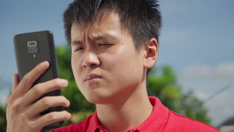 confused lost asian man using phone for navigation in digital age, rack focus