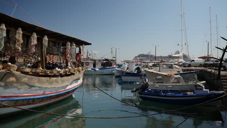 a selection of boats moored in rhodes town's habour including a shop boat selling natural sea products