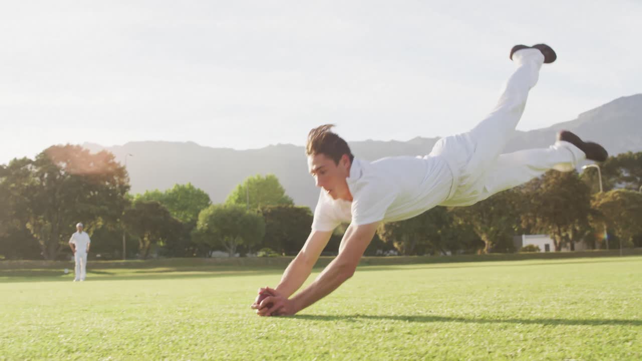 크리켓 선수 가 피치 에서 공 을 잡고 있다