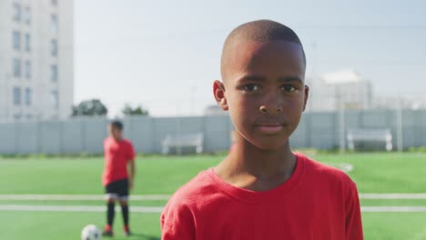 African-American-soccer-kid-in-red-smiling-and-looking-at-camera