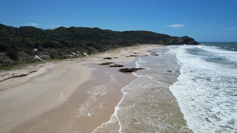 seascape with foamy waves in seven mile beach, new south wales, australia - drone shot